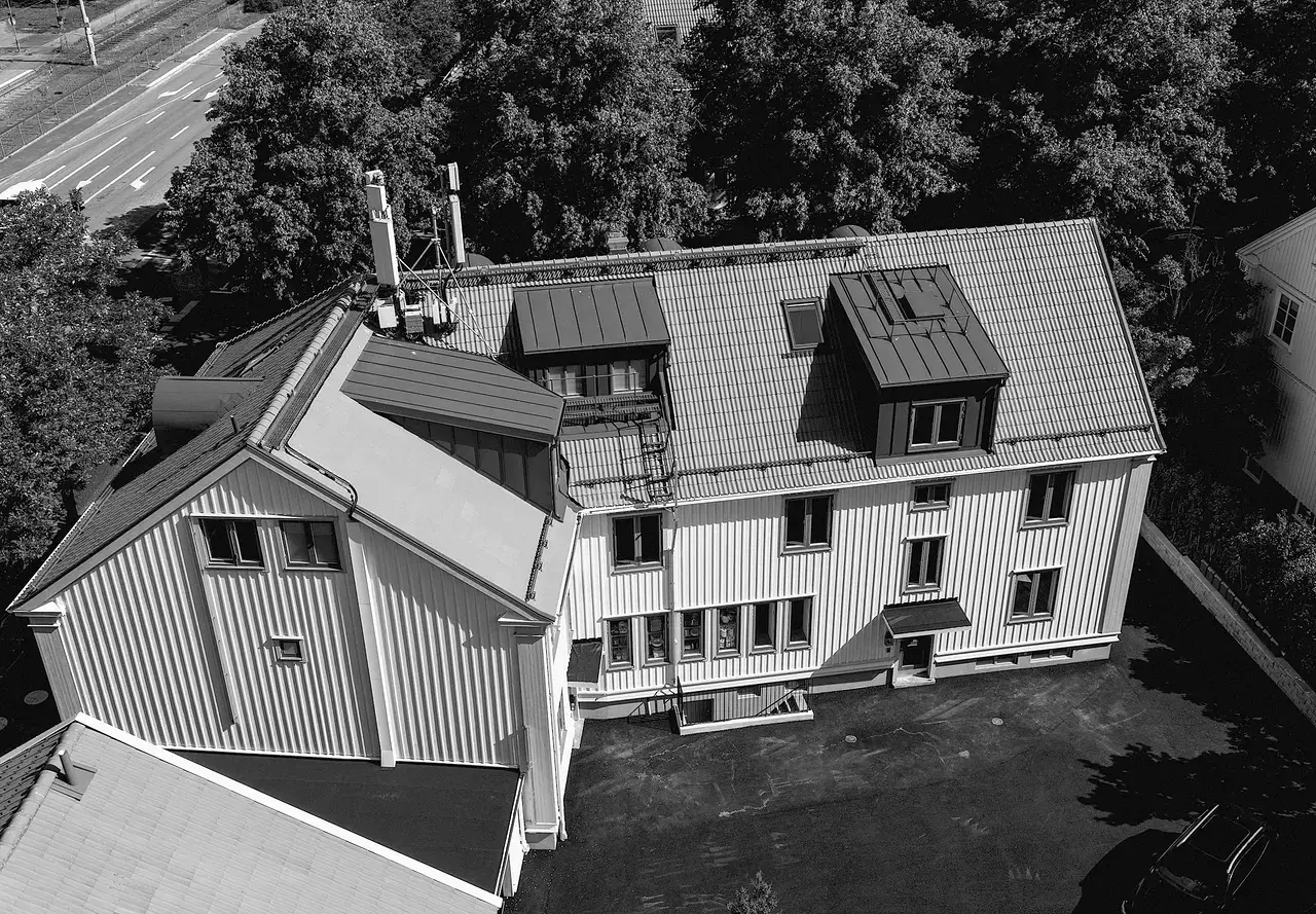 Sanatoriegatan 15 Kålltorp ett flervåningshus med plåttak omgivet av träd.