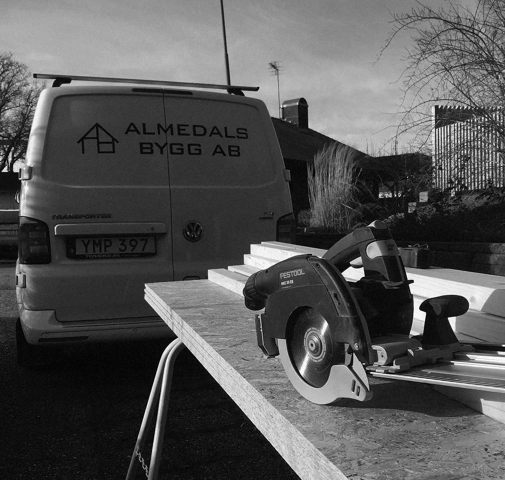 Festool cirkelsåg på träskiva framför Almedals Bygg AB:s skåpbil.